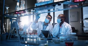 Photo of two scientists collaborating at bench