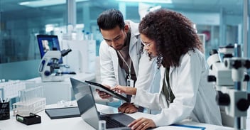 Two scientists in lab looking at data