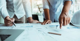 Photo of two people and architectural blueprints