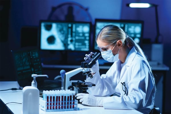 Photo of scientist looking through microscope