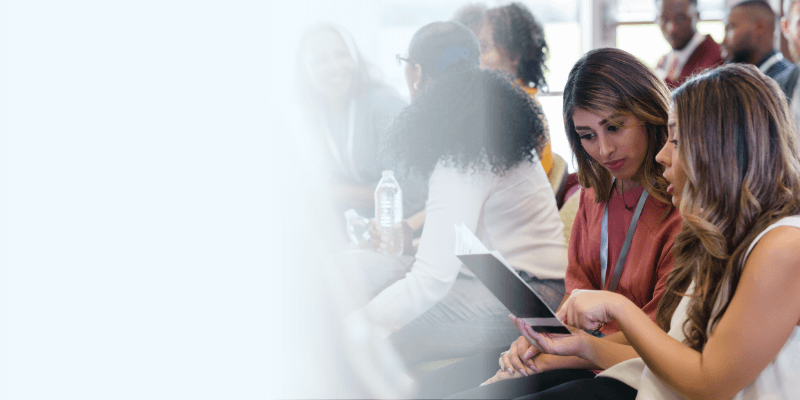 Two people at a conference, comparing notes