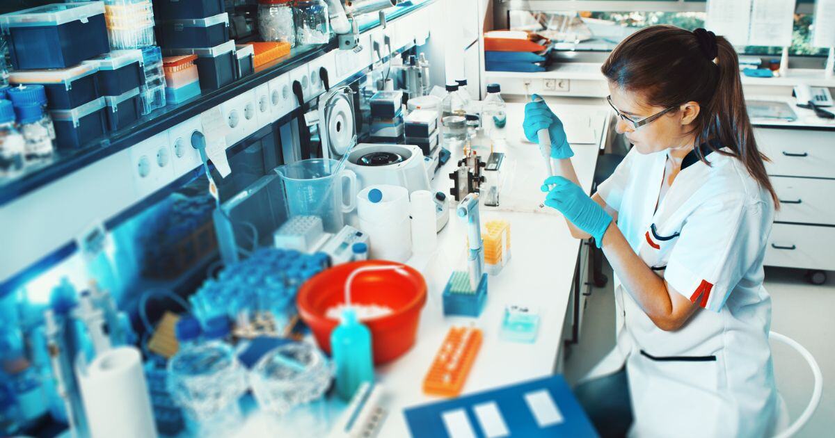 Scientist at bench surrounded by lab supplies